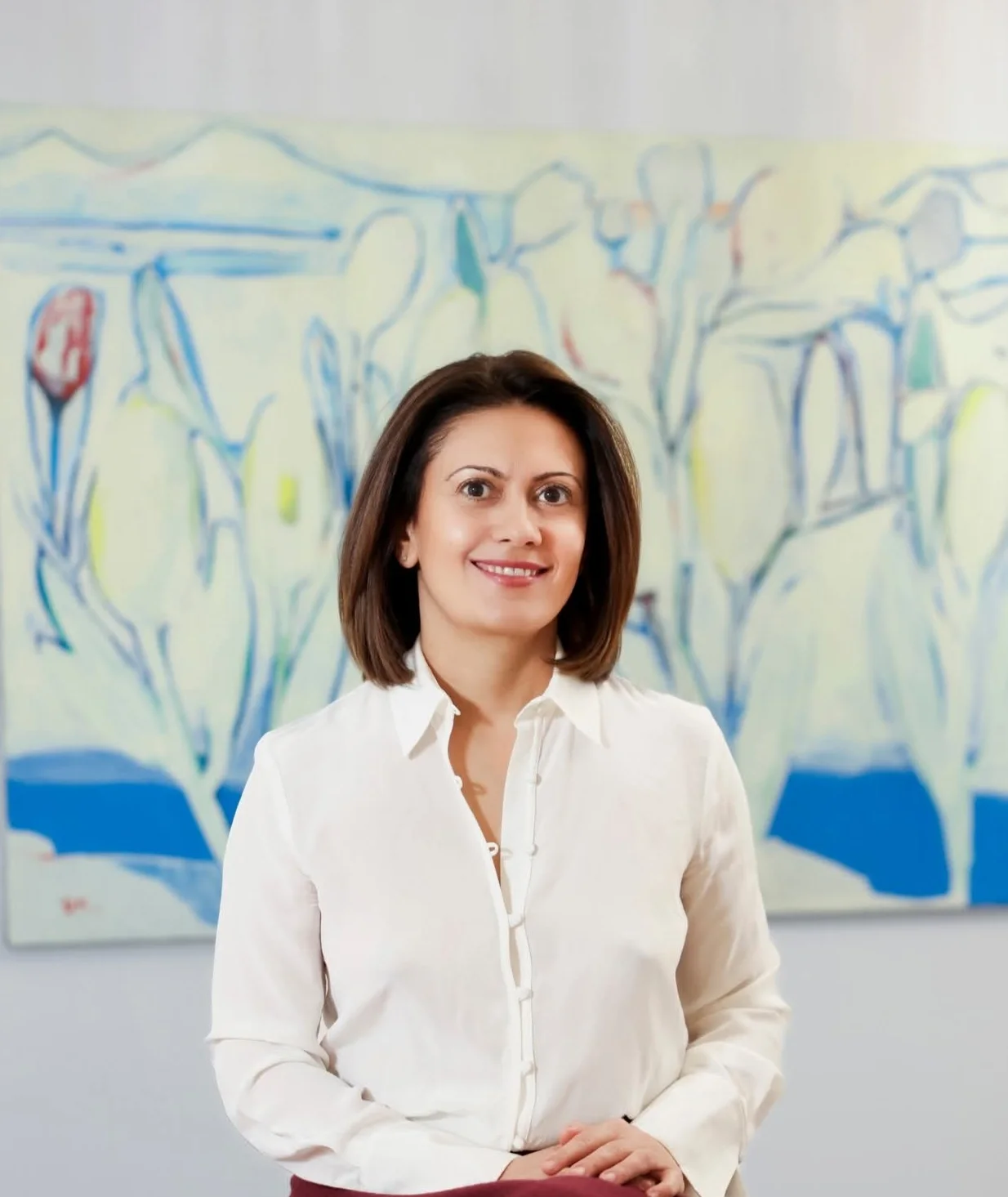 Tamar Hovsepian seated in front of a painting.