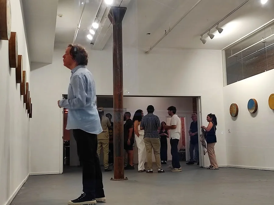 Visitors viewing artworks in a gallery.