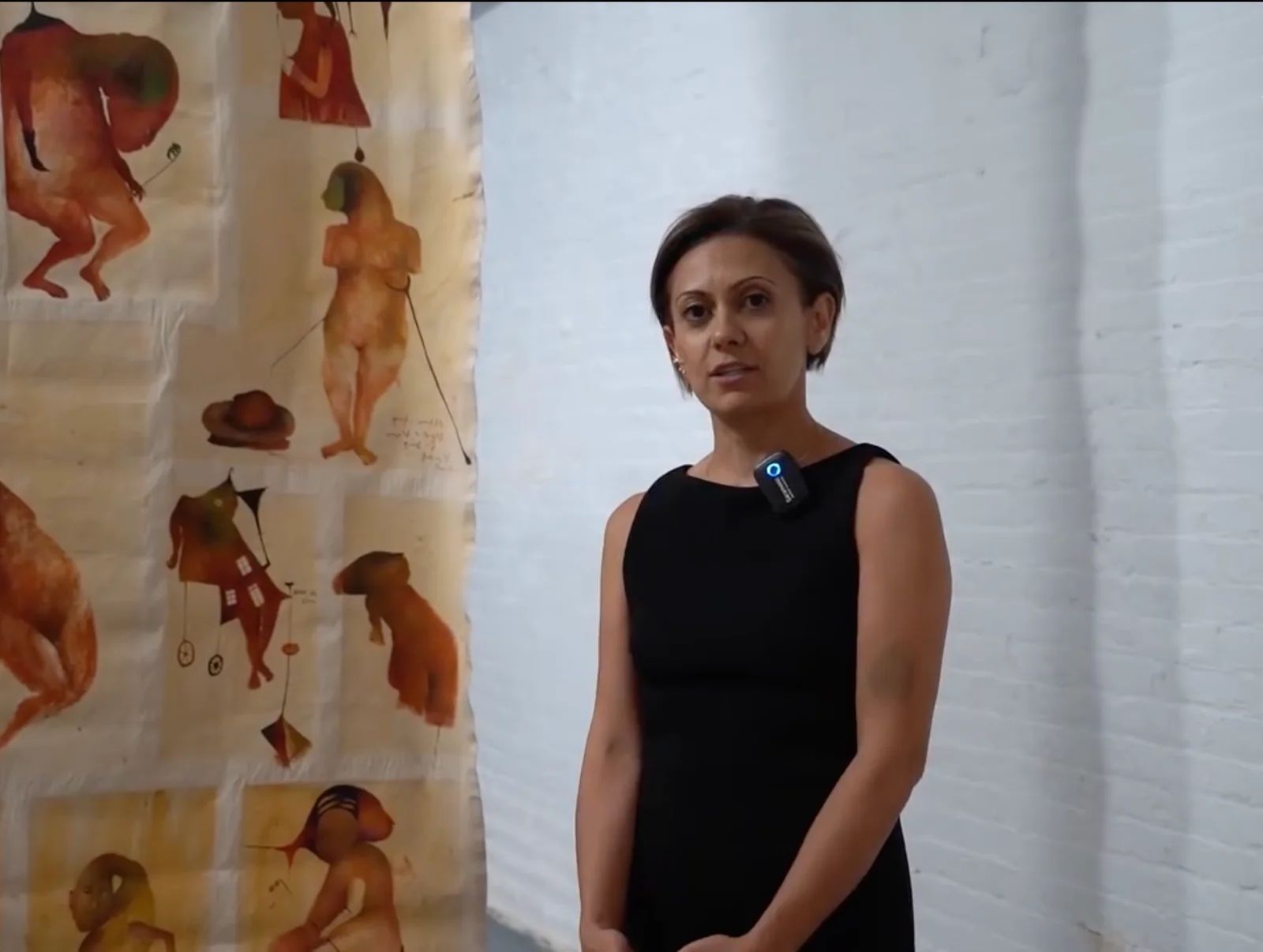 Tamar Hovsepian standing in front of artworks.