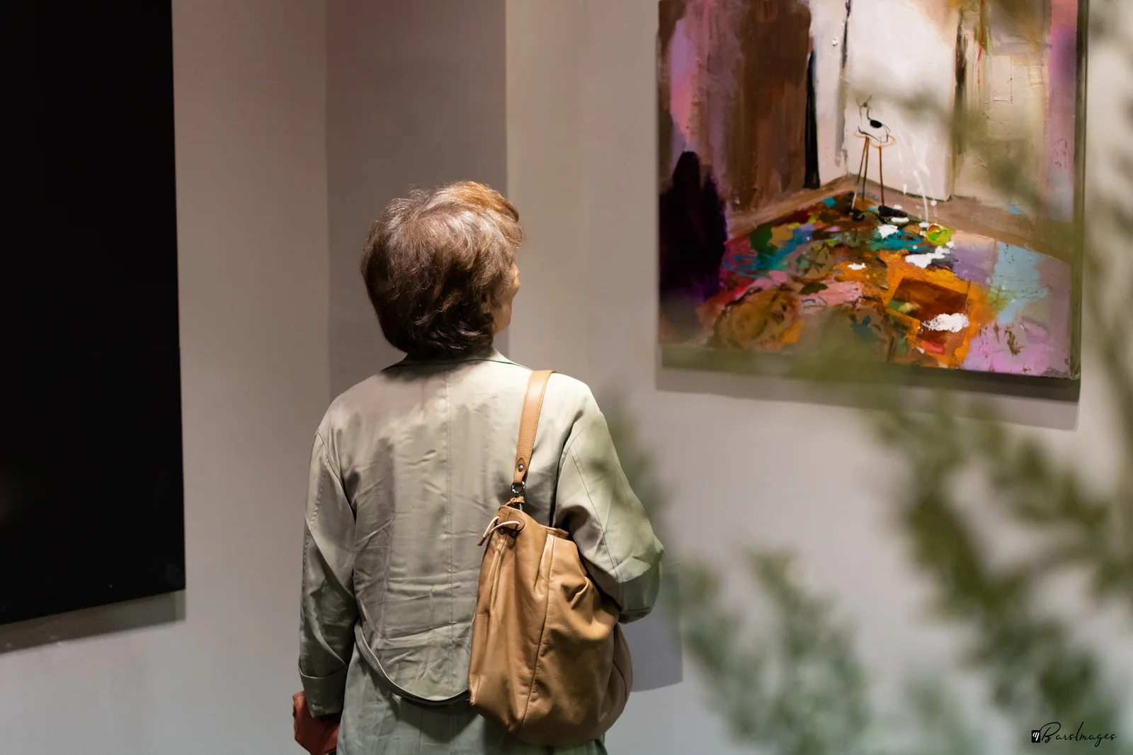 A visitor looking at paintings in a gallery.